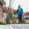 Happy runner in a blue hoodie running down a street